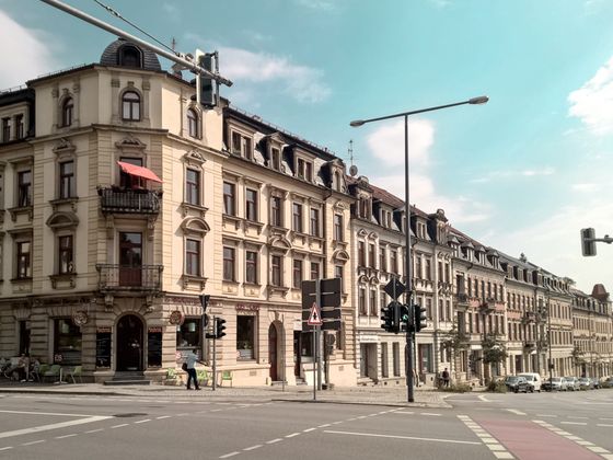 Straßenkreuzung mit Gründerzeithäusern im Abendlicht. Die Praxis befindet sich im Eckhaus im ersten Obergeschoss.